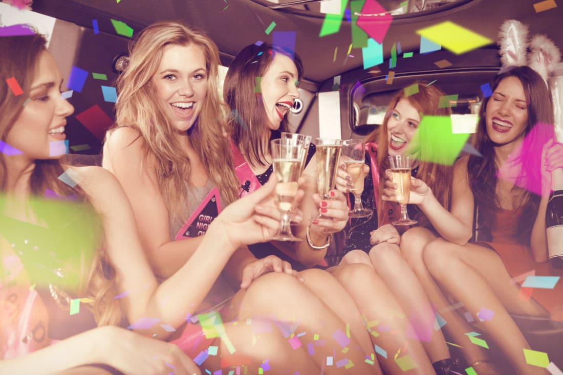 Bachelorette party celebrating in the back of a chauffeured limousine